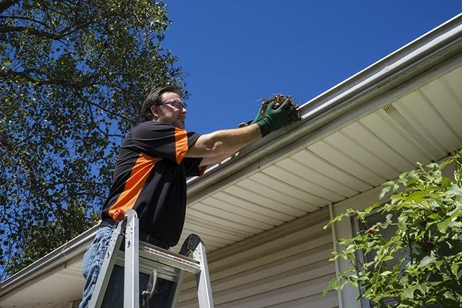 home improvement professional repairing a clogged gutter in Beverly Shores, IN